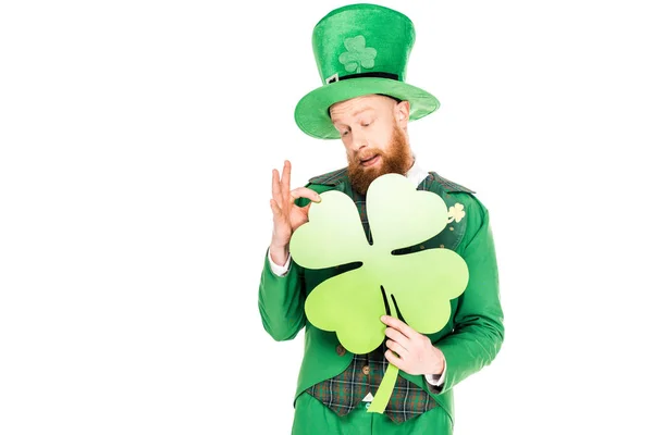 Bel leprecauno in tuta verde che tiene trifoglio, isolato su bianco — Foto stock