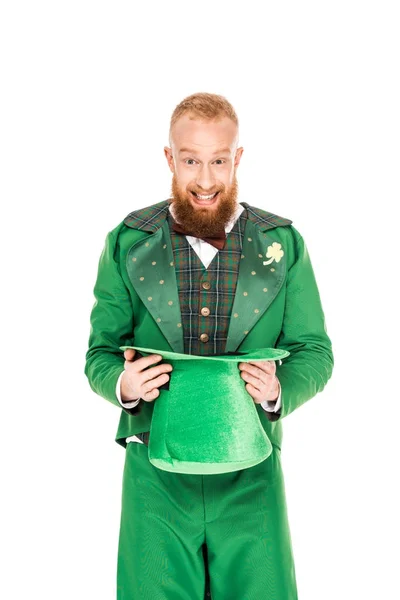 Hombre guapo en traje de duende sosteniendo sombrero verde, aislado en blanco - foto de stock