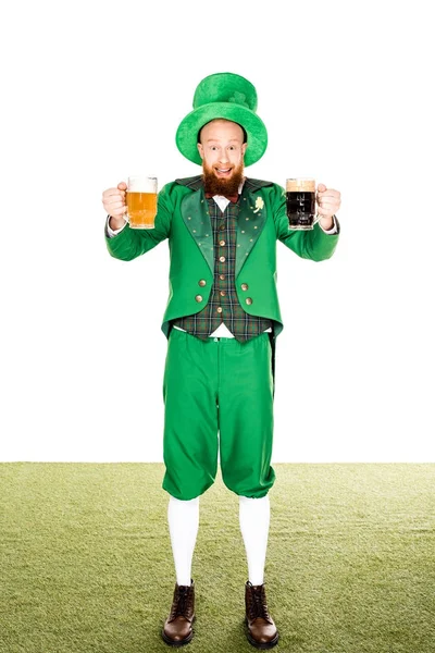 Leprechaun souriant tenant des verres de bière et regardant la caméra sur blanc — Photo de stock