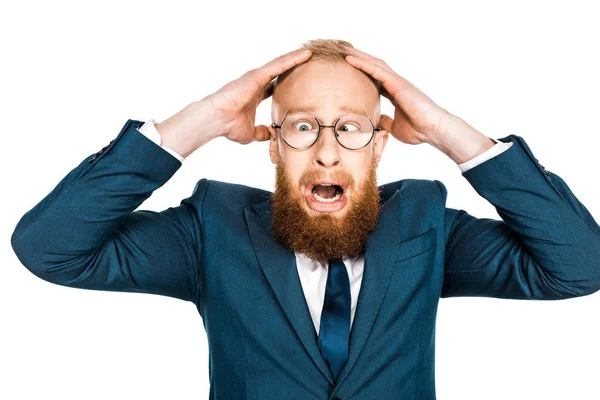 Homem de negócios barbudo assustado em óculos de mãos dadas na cabeça isolado em branco — Fotografia de Stock