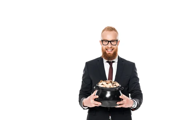 Bärtiger Geschäftsmann in Brille, Topf mit Münzen in der Hand und Blick in die Kamera isoliert auf weiß — Stockfoto