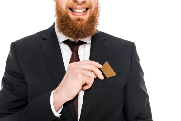 Обрізаний знімок усміхненого бородатого бізнесмена, який тримає кредитну картку ізольовано на білому — стокове фото