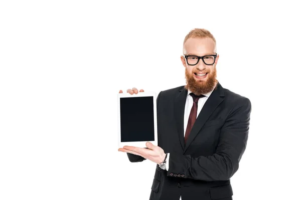 Guapo hombre de negocios barbudo sosteniendo tableta digital con pantalla en blanco y sonriendo a la cámara aislada en blanco - foto de stock