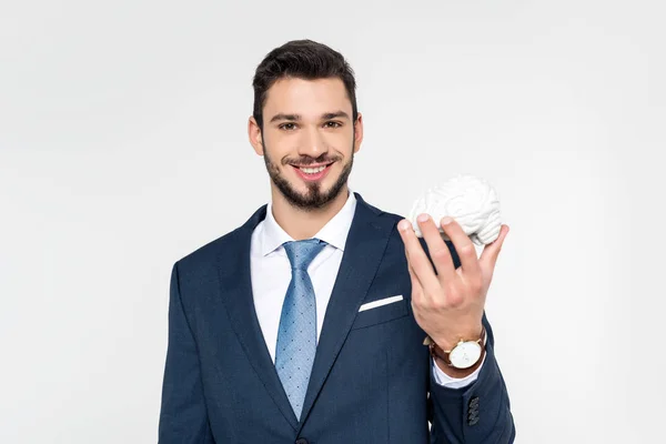Молодий бізнесмен тримає модель мозку і посміхається на камеру ізольовано на сірому — стокове фото