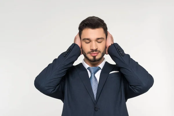 Jeune homme d'affaires détendu les yeux fermés fermant les oreilles avec les mains isolées sur gris — Photo de stock