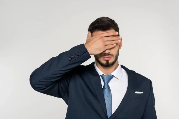 Молодий бізнесмен закриває очі пальмою ізольовано на сірому — стокове фото