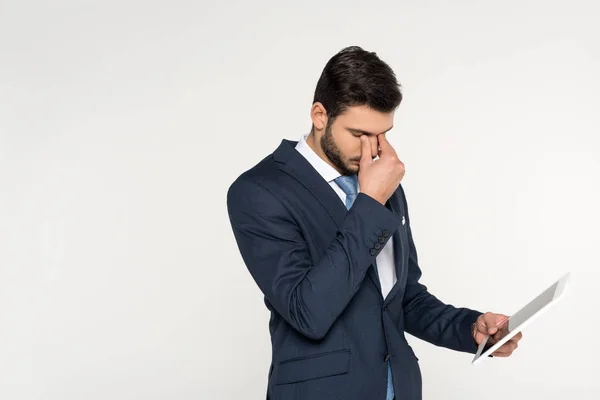 Fatigué jeune homme d'affaires tenant tablette numérique isolé sur gris — Photo de stock