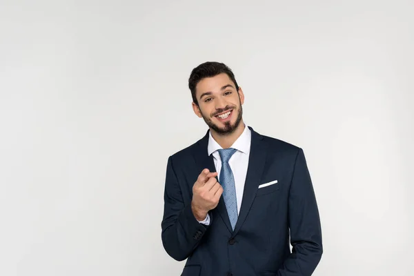 Cheerful young businessman pointing at camera isolated on grey — Stock Photo