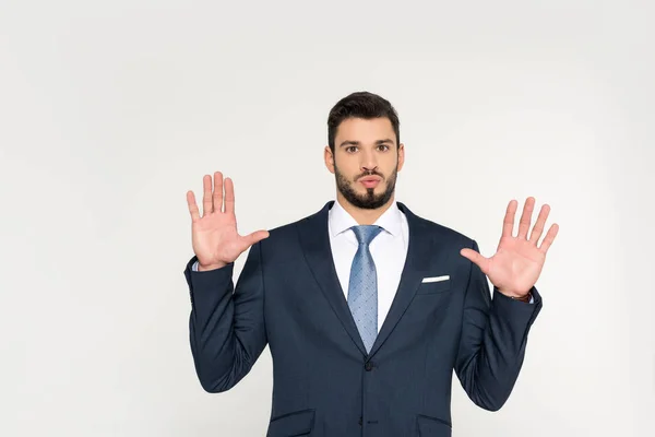 Young businessman with open palms looking at camera isolated on grey — Stock Photo