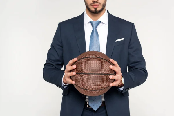 Recortado disparo de joven empresario sosteniendo pelota de baloncesto aislado en gris - foto de stock