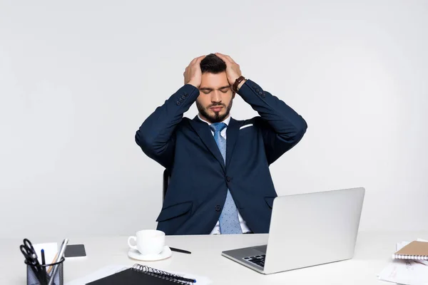 Joven empresario estresado con dolor de cabeza mientras está sentado en el lugar de trabajo — Stock Photo