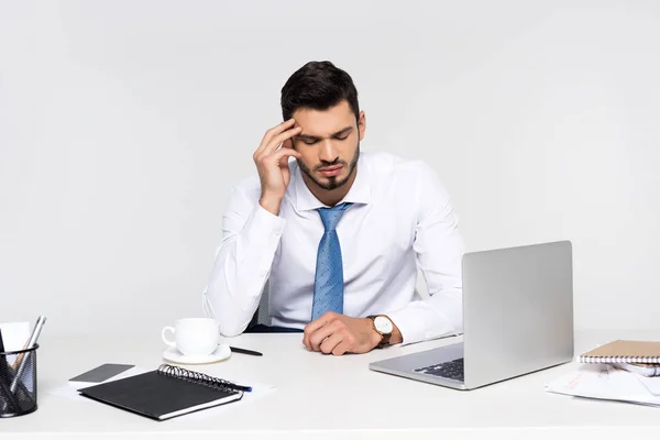 Giovane uomo d'affari oberato di lavoro che soffre di mal di testa mentre è seduto sul posto di lavoro — Foto stock