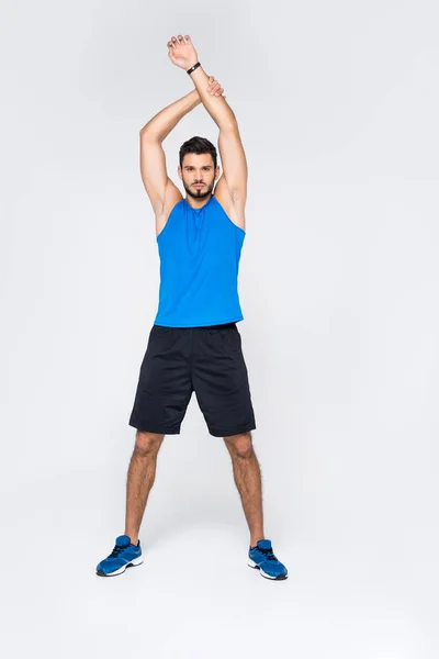 Full length view of handsome sporty man stretching hands and looking at camera isolated on white — Stock Photo