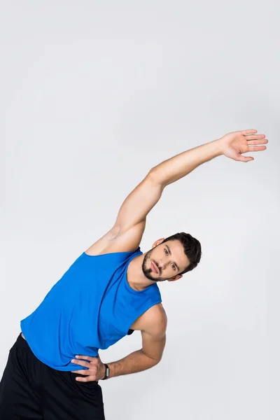 Sportive young man doing side bend isolated on white — Stock Photo