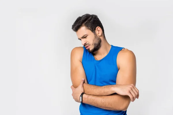 Sportif jeune homme avec douleur au bras isolé sur blanc — Photo de stock