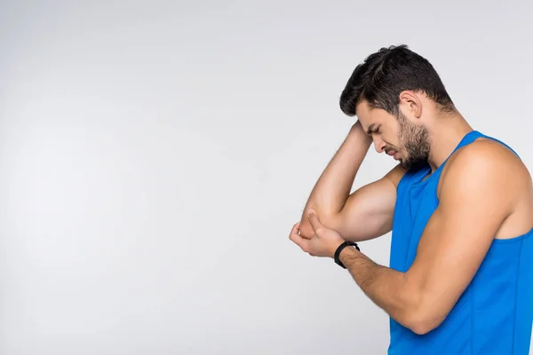 Vista lateral del joven con dolor en el brazo aislado en blanco - foto de stock