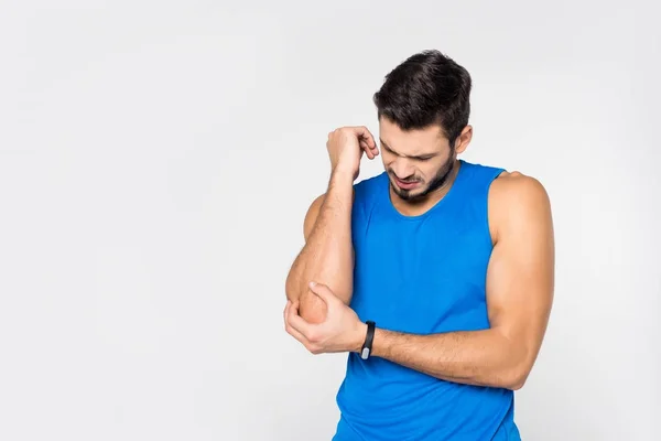 Beau jeune homme avec douleur au bras isolé sur blanc — Photo de stock