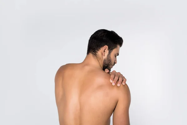 Back view of young shirtless man with pain in shoulder isolated on white — Stock Photo
