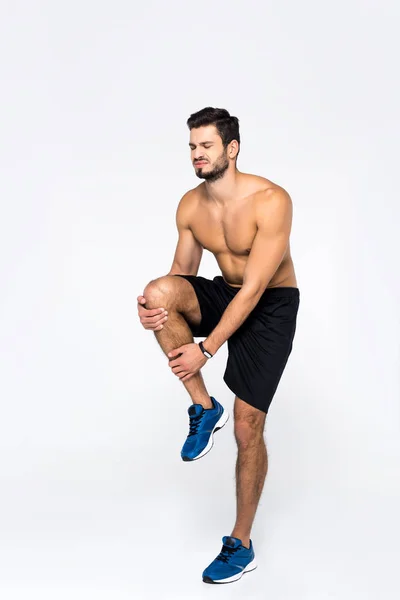 Athletic shirtless man with knee pain isolated on white — Stock Photo