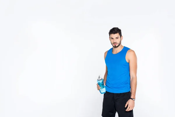 Jovem esportivo com garrafa de fitness isolado em branco — Fotografia de Stock