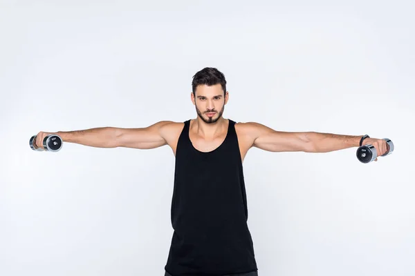 Sportive young man working out with dumbbells isolated on white — Stock Photo