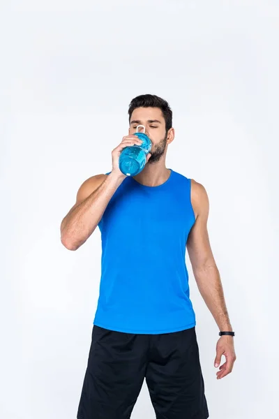 Young man drinking water from fitness bottle isolated on white — Stock Photo