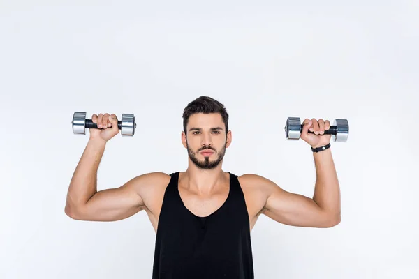 Handsome young man working out with dumbbells isolated on white — Stock Photo