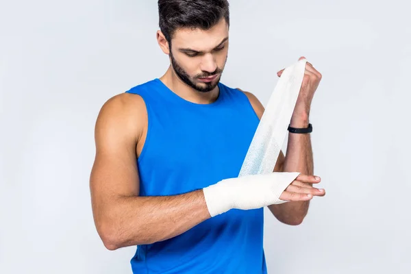 Giovane uomo che copre il polso con benda isolata su bianco — Foto stock