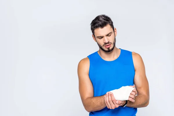 Sportive young man with wrist pain isolated on white — Stock Photo