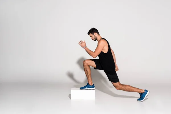 Side view of athletic man doing step aerobics on block — Stock Photo