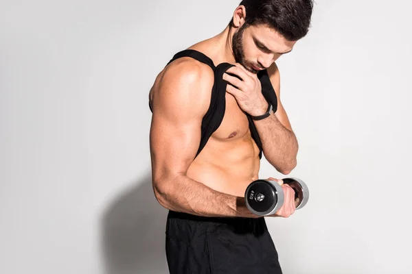 Handsome young man working out with dumbbell — Stock Photo