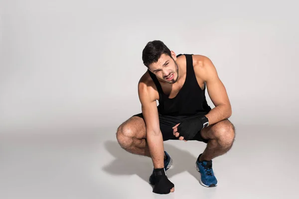 Erschöpfter junger Kämpfer sitzt auf weißer Fläche — Stockfoto