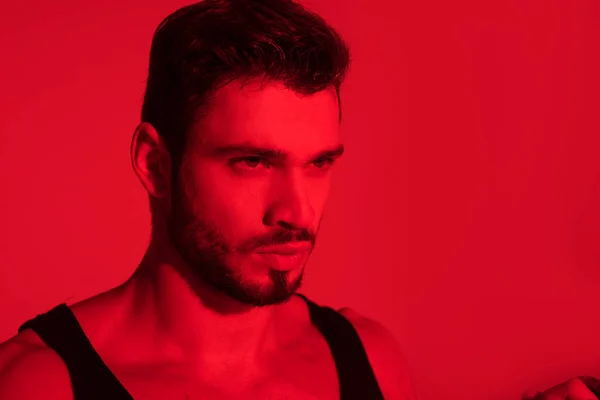 Portrait en gros plan d'un beau jeune homme sous la lumière rouge — Photo de stock