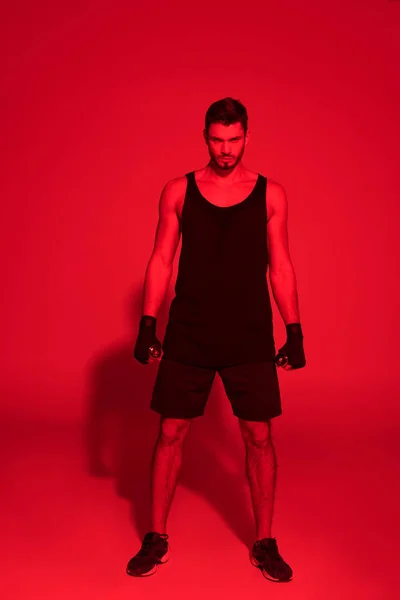 Angry young fighter under red light — Stock Photo