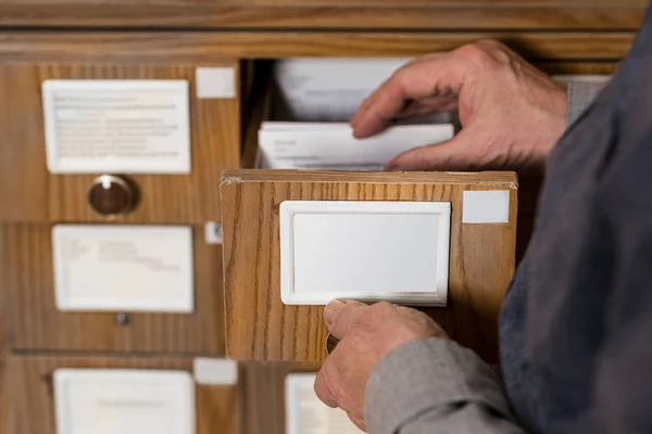 Immagine ritagliata di senior archivista maschile alla ricerca di cataloghi — Foto stock