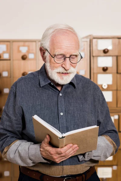 Senior male archivist reading book — Stock Photo