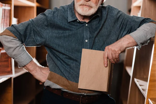 Обрізане зображення сірого волосся бібліотекар тримає книгу — стокове фото