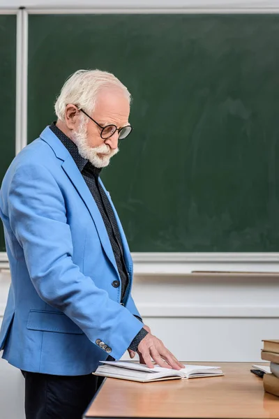 Professore di capelli grigi guardando il libro — Foto stock