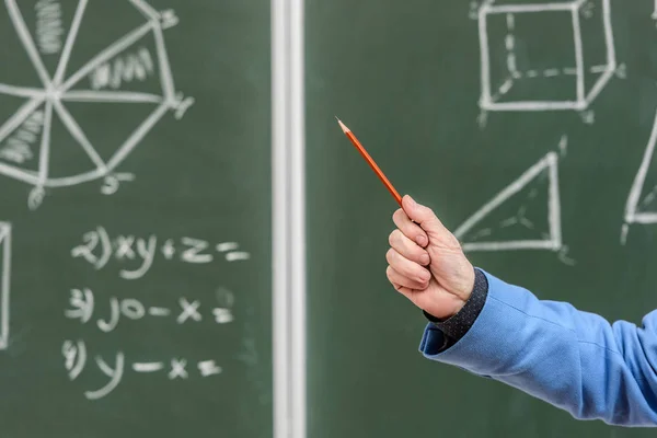 Abgeschnittenes Bild eines Professors, der mit Bleistift auf etwas an der Tafel zeigt — Stockfoto