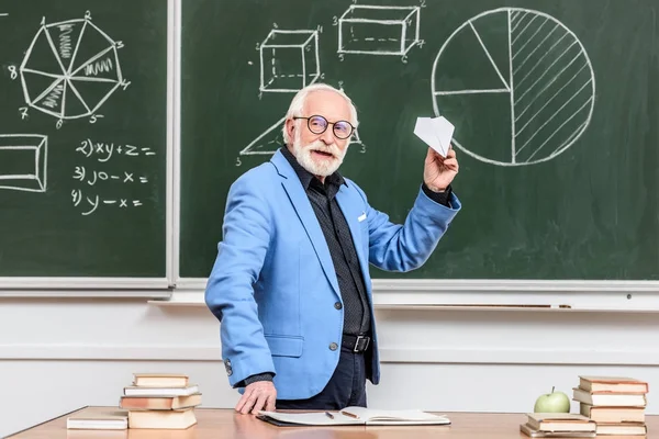Glücklicher Senior-Dozent hält Papierflieger in der Hand — Stockfoto