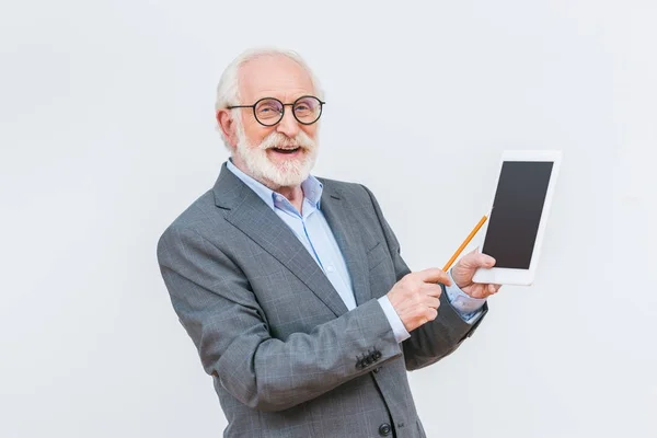 Lächelnder Senior Dozent zeigt auf Tablet isoliert auf Weiß — Stockfoto