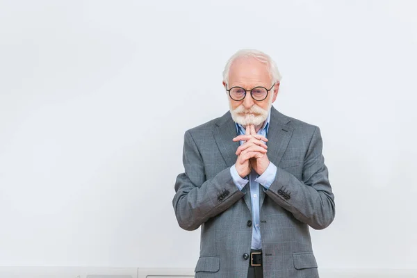 Pensativo profesor senior mirando hacia abajo en blanco - foto de stock