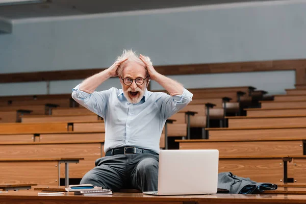 Senior lecturer in empty lecture room screaming and looking at camera — Stock Photo