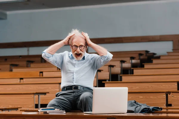 Senior Dozent im leeren Hörsaal schreit und blickt in die Kamera — Stockfoto