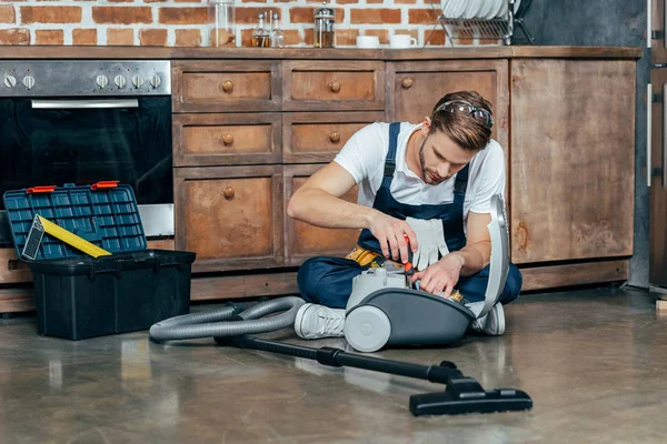 Professional repairman fixing vacuum cleaner — Stock Photo