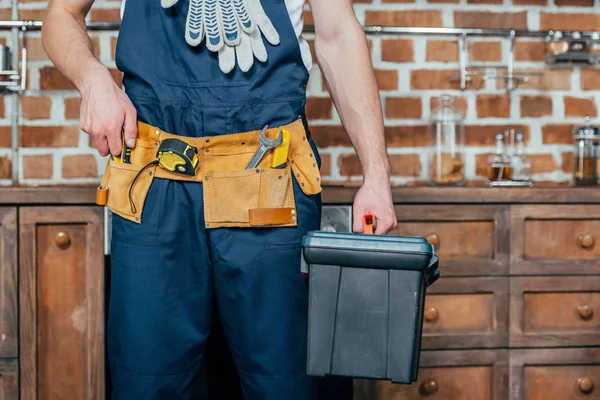 Mittelteil des Hausmeisters mit Werkzeuggürtel, der Werkzeugkiste hält — Stockfoto