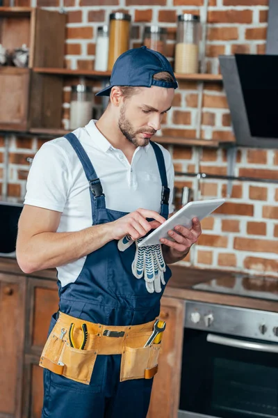 Beau jeune maître professionnel à la maison en utilisant une tablette numérique — Photo de stock