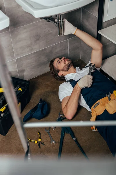 Selective focus of young male plumber fixing sink in bathroom — Stock Photo