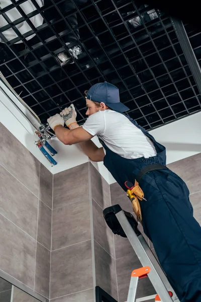 Low angle view of plumber working with pipes in bathroom — Stock Photo
