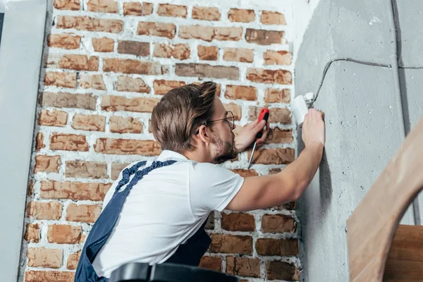 Side view of professional young electrician working with wires — Stock Photo